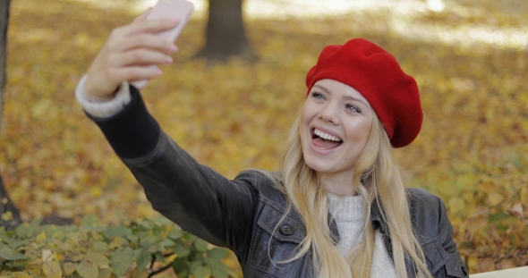Happy Woman Taking Selfie in Park alt