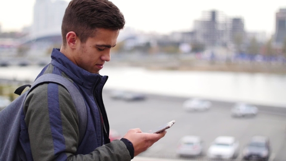 Smiling Handsome Man Writing Sms Message on the Phone