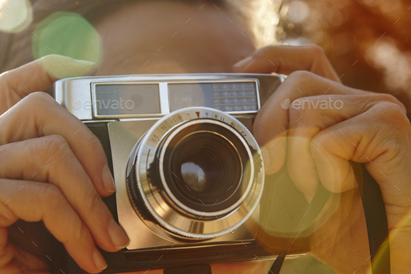 Woman taking pictures with vintage camera. Travel background. Fall season