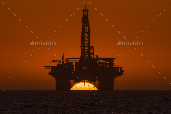 Sun setting behind oil drilling platform at Longbeach in Namibia - Stock Photo - Images