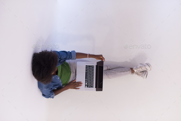 african american woman sitting on floor with laptop top view