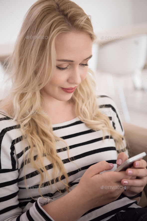 woman sitting on sofa with mobile phone