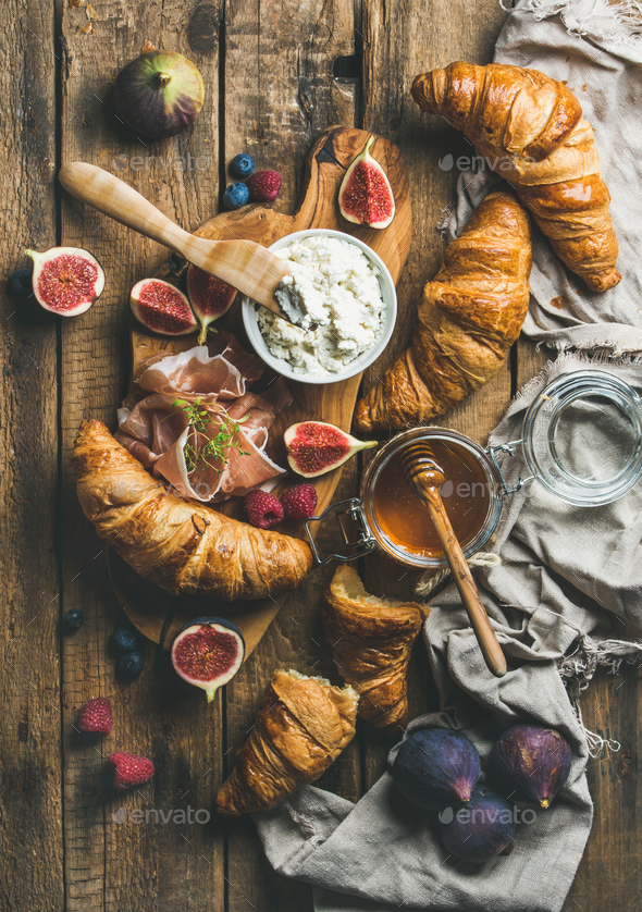 Croissants, ricotta cheese, figs, fresh berries, prosciutto and honey - Stock Photo - Images