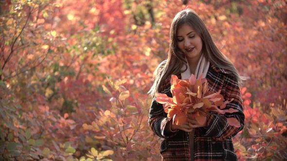 Beautiful Young Caucasian Girl with Makeup Poses on Camera in Autumn Forest