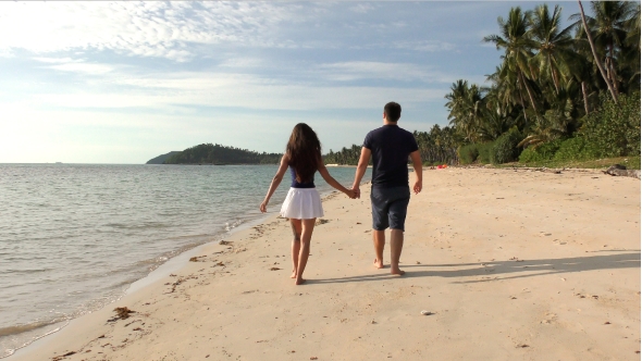 Romantic Coulpe Walking on the Beach at Sunset