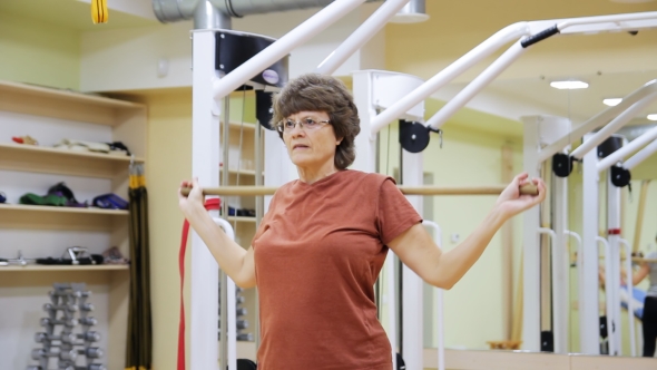 Elderly Woman Lifting Stick, Doing Physiotherapy Exercises with in Fitness Room. Healthy Gymnastics