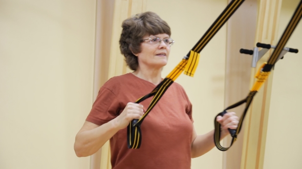 Elderly Woman Pulling Up, Doing Physiotherapy Exercises in Fitness Room. Healthy Gymnastics. Active