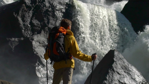 Backpacker Watches a Waterfall in .