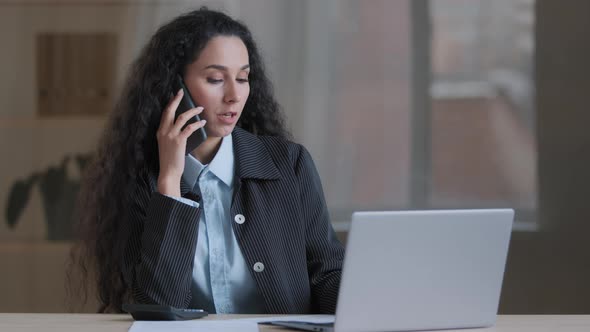 Serious Hispanic Business Woman Professional Entrepreneur Boss Work Multitasking Talk on Cellphone alt