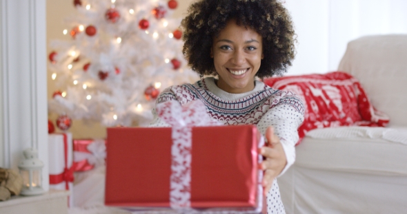 Smiling Friendly Woman Offering a Christmas Gift