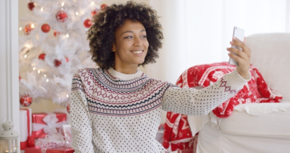 Happy Young Woman Posing for a Christmas Selfie