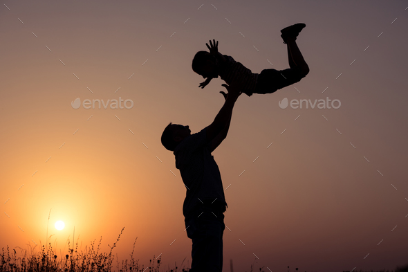 Father and son playing in the park at the sunset time. - Stock Photo - Images