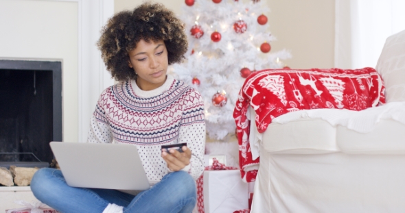 Young Woman Purchasing Christmas Gifts Online