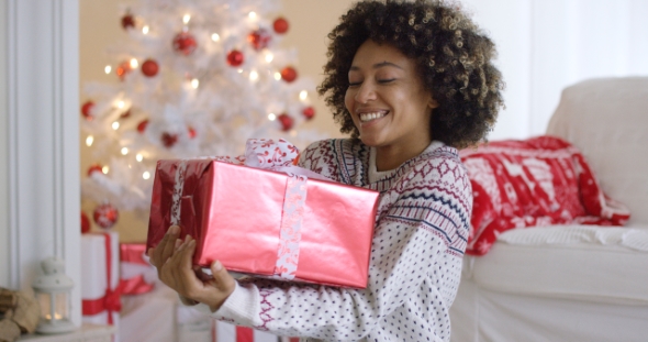 Happy Young Woman Holding a Christmas Gift