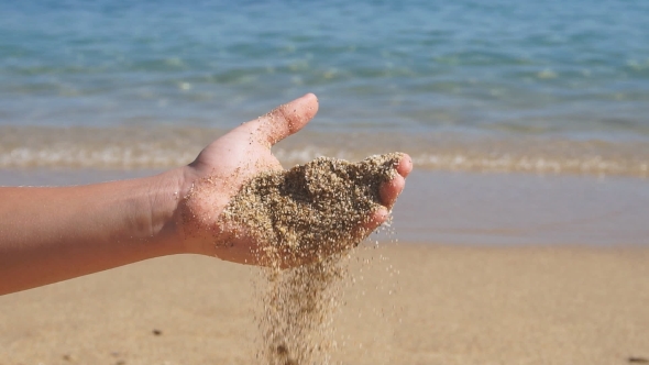 Sea Sand Running Through a Boy Hand. alt