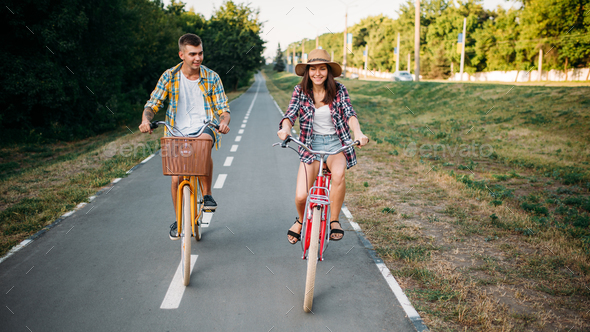 Love couple riding on retro bikes in summer park - Stock Photo - Images