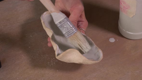 Potter Apply Glaze On Clay alt