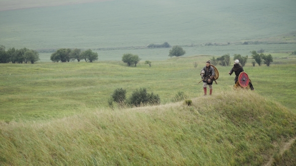 Group of Viking with Shields Walking Forward on the Meadow alt