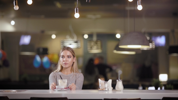 A Young and Pretty Woman Finished Her Coffee Latte in a Restaurant, the Lady Is Waiting alt