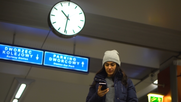 Girl with Braces Awaits the Arrival of the Train and Speaks on the Phone