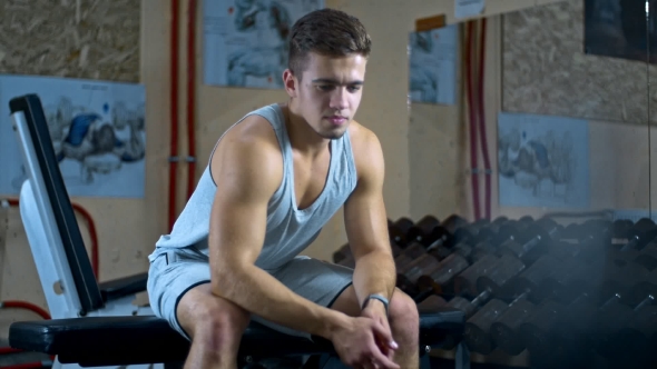 Exhausted Bend Muscular Man Rests After Intensive Workout