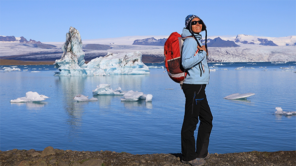 Young Woman Admires the Beauty of The Glacial Lagoon Jokulsarlon