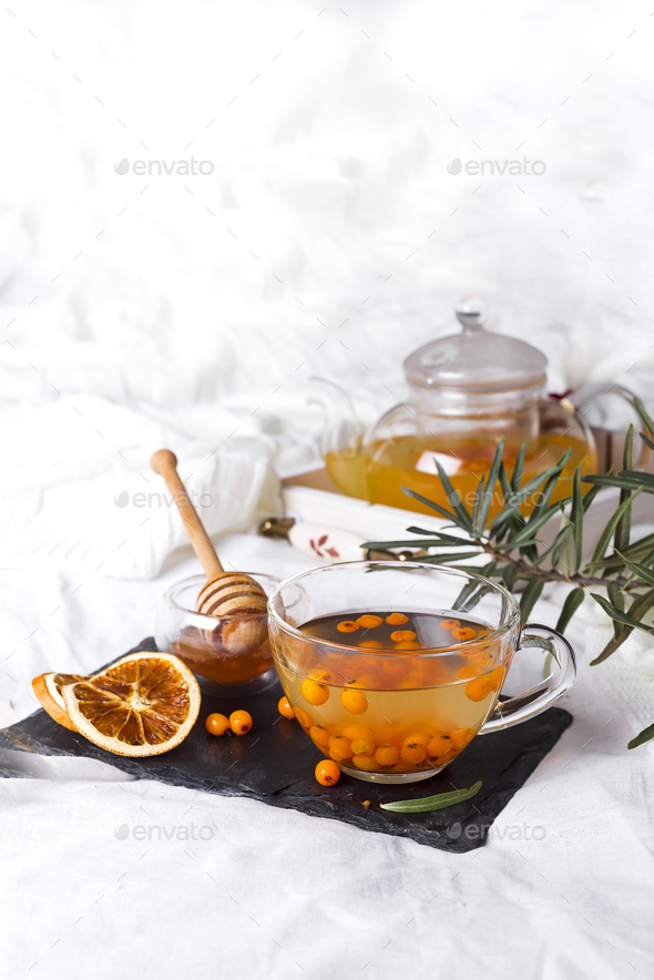 A glass teapot with sea buckthorn - Stock Photo - Images