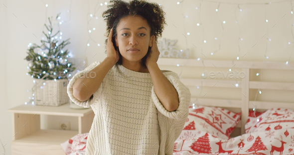 Calm young woman adusting hair in bed - Stock Photo - Images