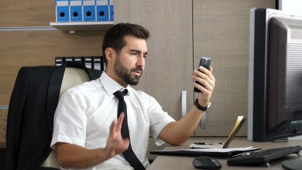 Young Attractive Businessman Having a Video Conference Via His Phone alt