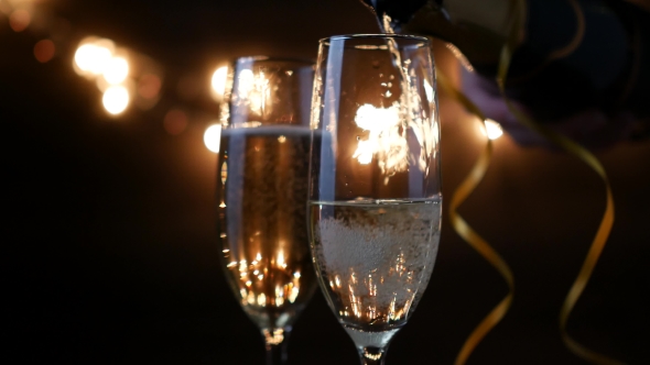 Two Flutes with Sparkling Wine Over Holiday Bokeh Blinking Background. Ultra  Footage.