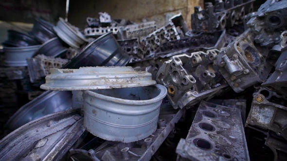 Metal Parts of Old Broken Automobiles Are Lying in Heaps of Scrap Metal in Large Hangar alt