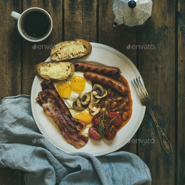 Traditional English breakfast with fried eggs, sausages, mushrooms, bacon, coffee - Stock Photo - Images