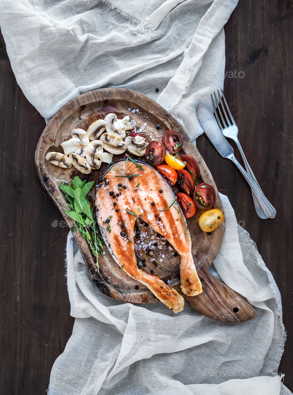 Grilled salmon steak with fresh herbs, roasted mushrooms, cherry - Stock Photo - Images