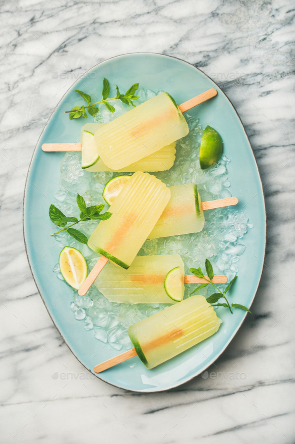 Summer lemonade popsicles with lime, mint leaves and chipped ice - Stock Photo - Images