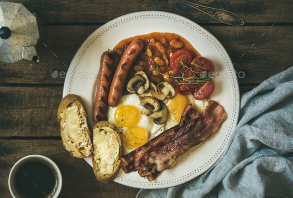 English breakfast with fried eggs, sausages, mushrooms, bacon, beans, coffee - Stock Photo - Images