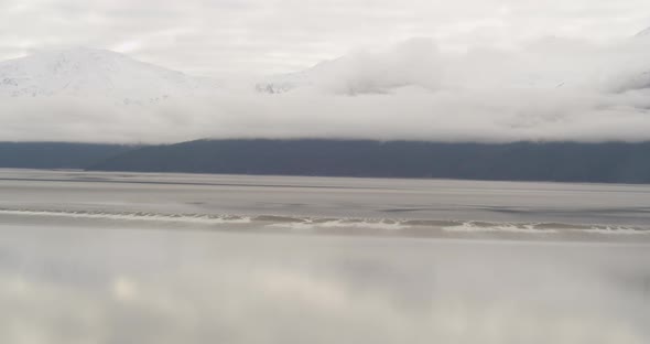 Aerial shot from wide to closeup across glacier floating in bay, drone helicopter footage alt