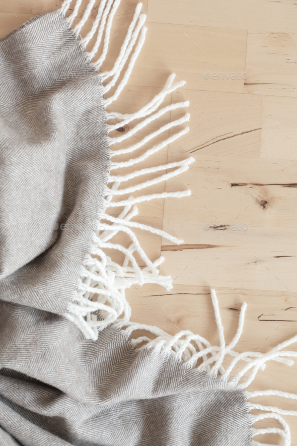 warm wool throw plaid on wooden background