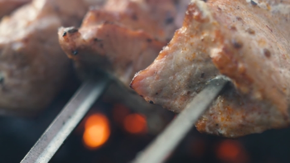 Grilled Shish Kebab on Metal Skewer. Chef Hands Cooking Roasted Meat Barbecue with Lots of Smoke
