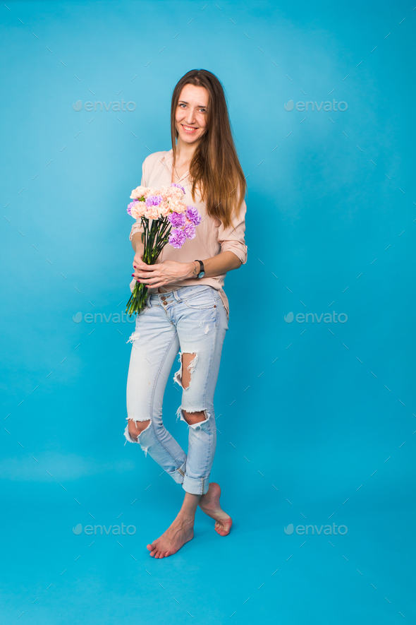 woman holding a bouquet of carnation flowers on a blue background