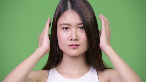 Young Beautiful Asian Businesswoman Covering Ears As Three Wise Monkeys Concept