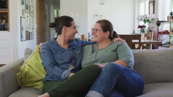Portrait of caucasian lesbian couple looking at camera, embracing alt
