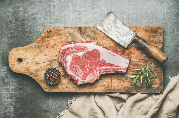Meat dinner concept with raw beef steak rib-eye with seasoning - Stock Photo - Images