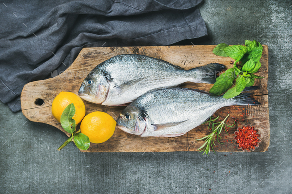 Uncooked sea bream or dorado fish with lemon - Stock Photo - Images