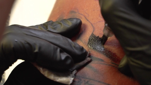 Tattoo Applying Ink on Skin with Tattoo Machine