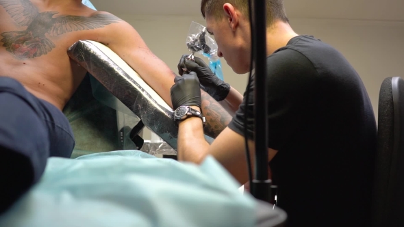 Master Makes a Tattoo on the Client's Arm