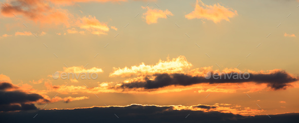 Beautiful sunset on sky. Gold sun hides behind the clouds.