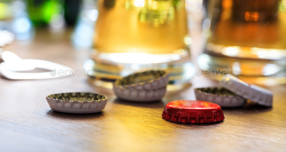 Beer caps and glasses of beer on a pub background