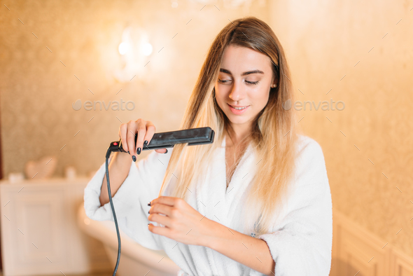 Woman with curling iron, bathroom on background Stock Photo by NomadSoul1