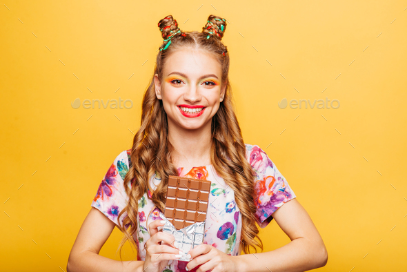 Young smiling lady holds chocolate bar - Stock Photo - Images