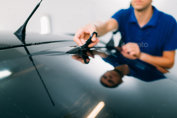 Worker with scissors, car tinting installation - Stock Photo - Images